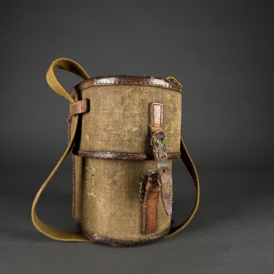 un vieux sac en toile muni d'une sangle et d'une poignée en cuir