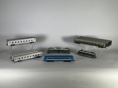 quatre modèles réduits de trains posés sur une surface blanche