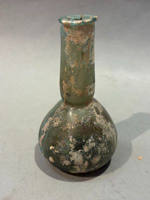 a green glass vase sitting on top of a table
