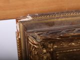 a close up of a gold frame with a mirror in it