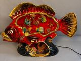 a red and gold fish statue on a white surface