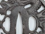a metal plate with a dragon on it on a white surface