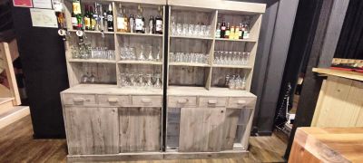 une grande armoire en bois sur laquelle sont posés des verres à vin