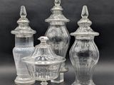 three clear glass jars with lids on a black background