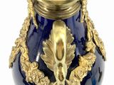 a blue vase with a gold decoration on it