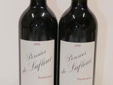 two bottles of red wine sitting next to each other on a table