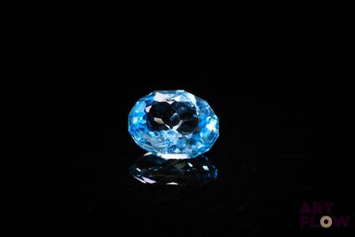 a close up of a blue topaz diamond on a black surface