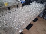 several rows of empty wine glasses on a table in a restaurant