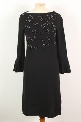 une robe noire avec des paillettes sur les épaules et des manches cloche