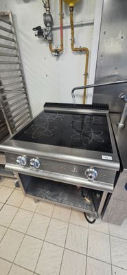 a stove in a commercial kitchen with a lot of cooking equipment