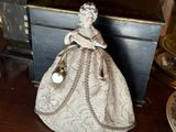 une figurine représentant une femme en robe, posée sur une table