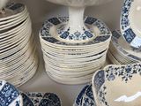 many blue and white plates and bowls stacked on a shelf