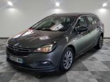 La voiture grise est garée sur un sol à damier dans un showroom.