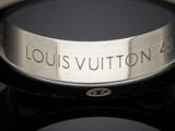 a silver ring with the word louis vuitton engraved on it