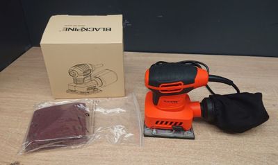 Ponceuse orbitale Black & Decker avec son coffret et ses accessoires, posée sur une table