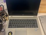 a laptop computer sitting on top of a desk next to a cell phone