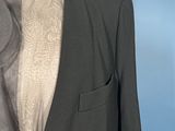 a mannequin mannequin with a black jacket and grey shirt