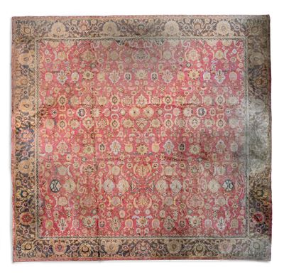 un tapis persan ancien à fond rose et bordure dorée