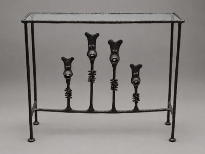 une console en fer noir à quatre pieds avec un plateau en verre