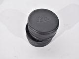 the lid of a black leather pill case on a white surface