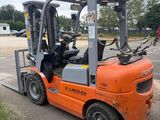 an orange forklift truck parked in a parking lot next to a parking lot