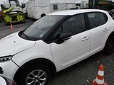 a small white car parked in a parking lot