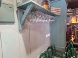 many empty wine glasses on the shelves in this restaurant