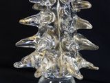 a glass christmas tree that is sitting on a table