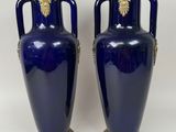 pair of blue vases with gold handles and handles on a white background