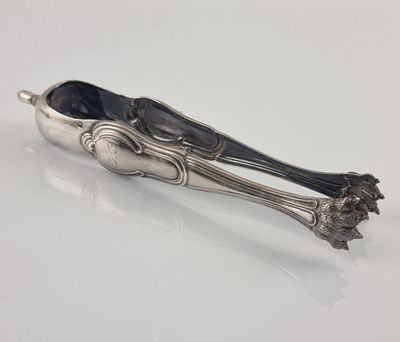 an antique silverware spoon and tonget on a white surface