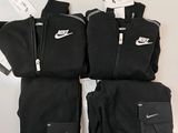 the nike tracksuits are black and have white logos on them