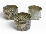 trois tasses en argent posées l'une à côté de l'autre sur une surface blanche