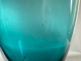 a blue glass vase that is sitting on a table