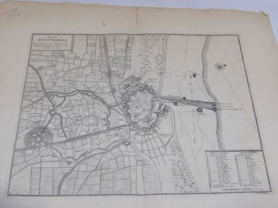 une vieille carte d'une ville posée sur une table, avec un stylo et de l'encre