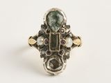 un gros plan d'une bague ornée d'une tourmaline verte entourée de perles