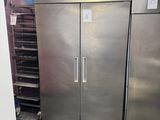 two stainless steel refrigerators in the middle of a room