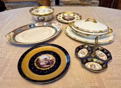 many plates and bowls sitting on a table with a stone wall in the background