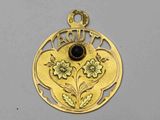 un gros plan d'un pendentif en or orné d'un motif floral
