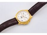 a close up of a watch on a brown leather strap