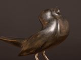 a bronze bird that is standing on a table