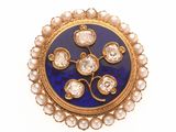an image of a gold and blue broochle with pearls