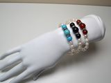 trois bracelets posés sur la main d'un mannequin, posée sur une table blanche