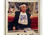a picture of a man sitting at a table with a drink in front of him