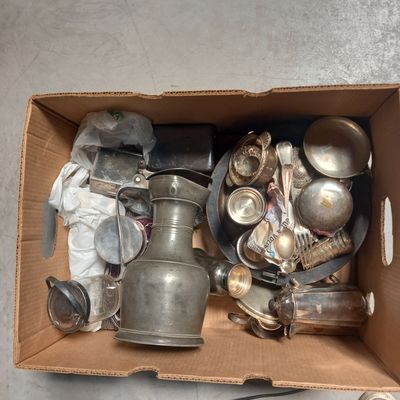 a cardboard box filled with silver items on the floor