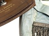 a brown purse sitting on top of a piece of clothing