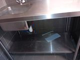 a stainless steel sink in a bathroom with a metal counter top