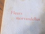 un vieux livre posé sur une table en bois, à côté d'un chiffre