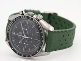 a watch with a green strap on a white surface