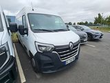 une camionnette blanche garée dans un parking à côté d'autres voitures