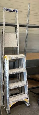 une échelle appuyée contre un mur, à côté d'une table